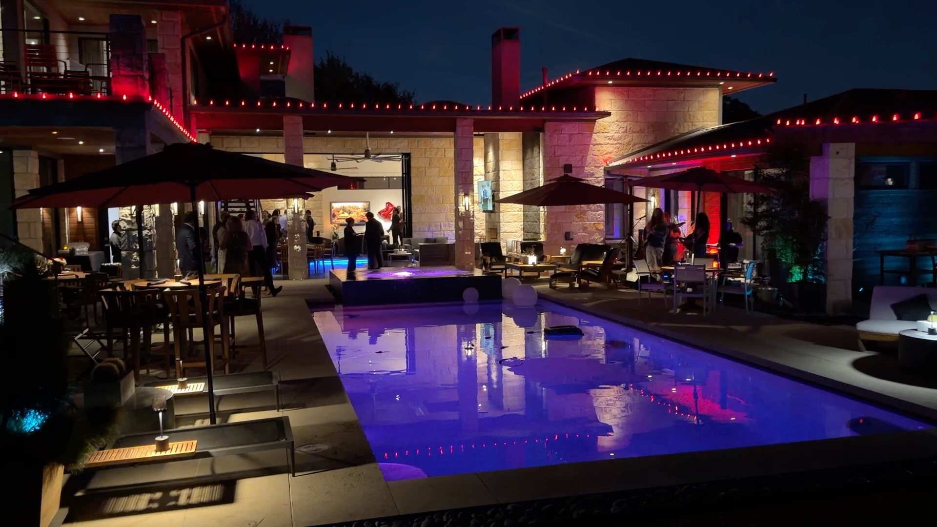Catered backyard pool party at night in Dallas